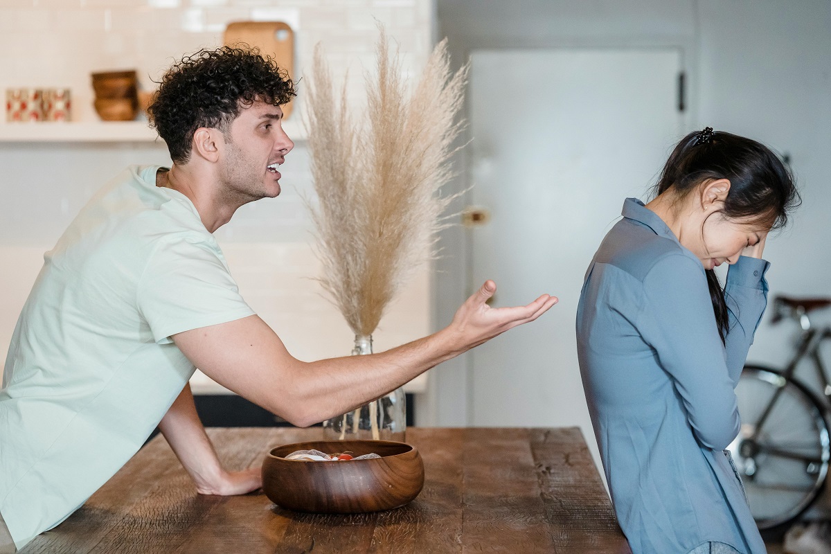 crying woman turns away from angry partner