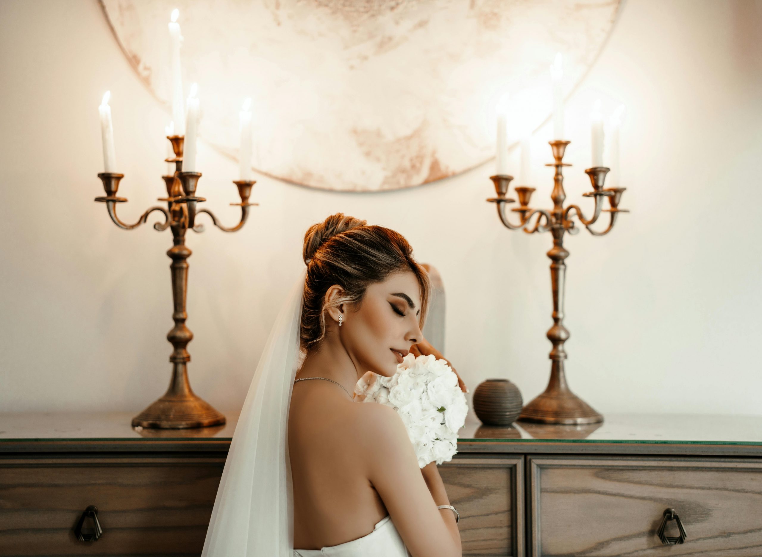 bride posing while holding a bouquet of white flowers