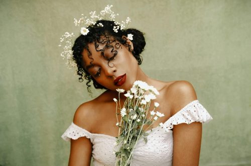 bride wearing full glam makeup, a flower crown, and holding white flowers