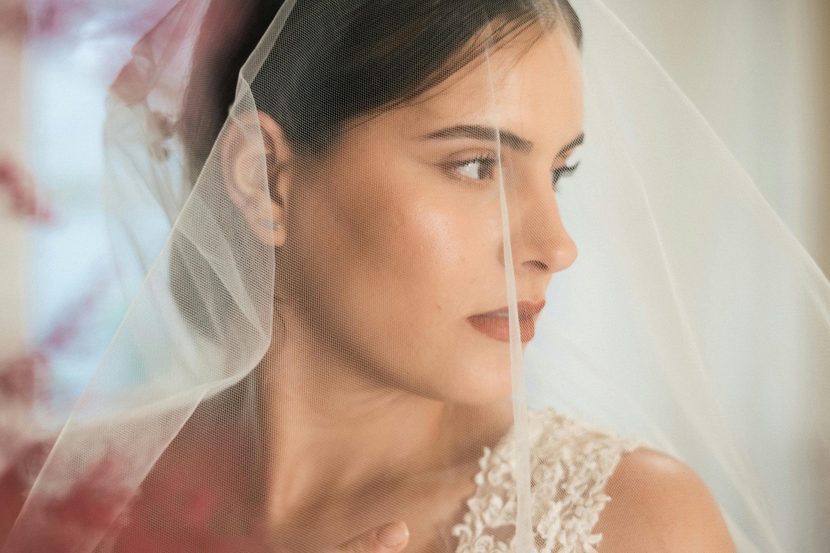 bride wearing a veil and bold red lipstick