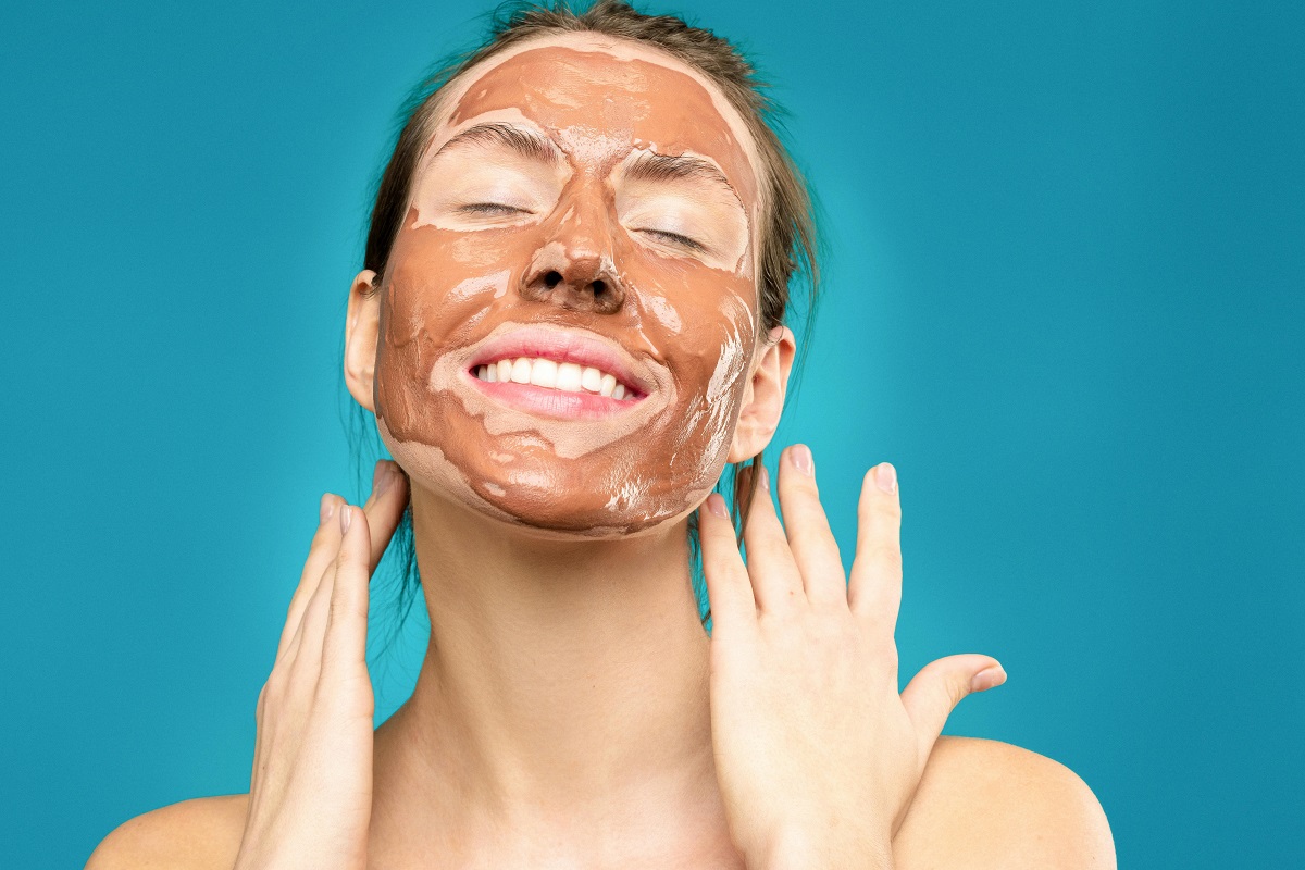 smiling woman with a skincare mask on her face