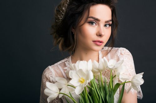 bride with a natural makeup look holding a white floral bouquet