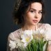 bride with a natural makeup look holding a white floral bouquet